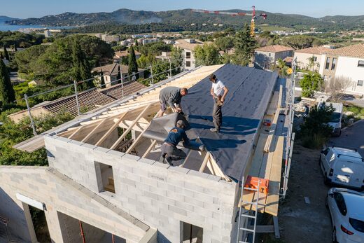 Vue drone d'une maison neuve en cours de couverture, écran sous-toiture posé