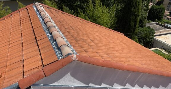 Solin en zinc découpé à redans sur une toiture en tuiles